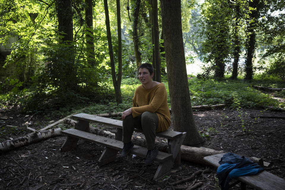 Activist Salome Dorfer sits on a bench inside the Luetzerath forest, Germany, Tuesday, July 20, 2021. Activists try to stop the village being evicted as a result of the the construction of a coal mine. (AP Photo/Bram Janssen)