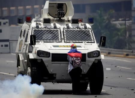 Una manifestante opositora bloque al paso a un vehículo de la policía antidisturbios durante una protesta contra el presidente de Venezuela, Nicolás Maduro, en Caracas. 19 de abril. REUTERS/Marco Bello