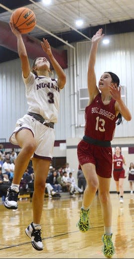 Nowata High's Trailee Watson, left, looks to shoot over Dewey High's Bailey Hughbanks during a girls basketball showdown on Dec. 2, 2022, in Nowata.