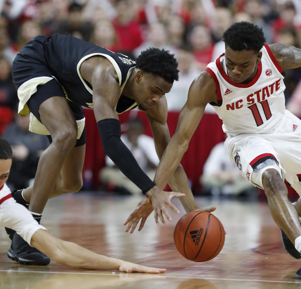 North Carolina State's Markell Johnson, right, and Wake Forest's Isaiah Mucius (1) go after the ball during the first half of an NCAA college basketball game in Raleigh, N.C., Friday, March 6, 2020. (Ethan Hyman/The News & Observer via AP)