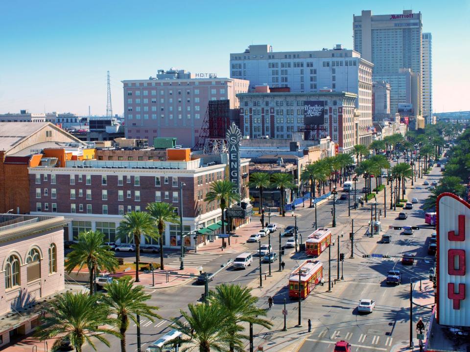 Red street cars on Canal Street pass by the renovated Saenger and Joy Theaters. Canal Street is New Orleans main street with shopping, dining and entertainment.