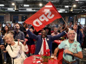 SPD supporters and members cheer at the election party of the Berlin SPD after the first forecasts for the outcome of the elections to the House of Representatives were announced, in Berlin, Sunday, Sept. 26, 2021. Exit polls show the center-left Social Democrats in a very close race with outgoing Chancellor Angela Merkel’s bloc in Germany’s parliamentary election, which will determine who succeeds the longtime leader after 16 years in power. (Bernd Von Jutrczenka/dpa via AP)