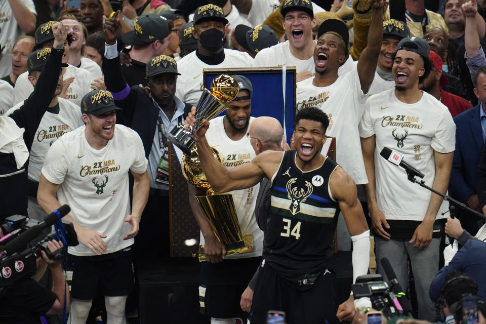 Giannis Antetokounmpo holds up the MVP trophy.