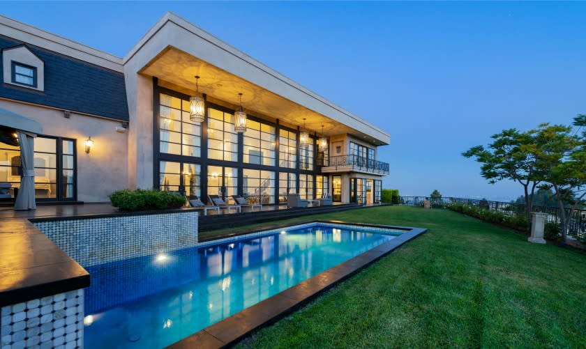 Perched above the Sunset Strip, the modern home holds a two-story great room that leads to a solar-heated saltwater pool.