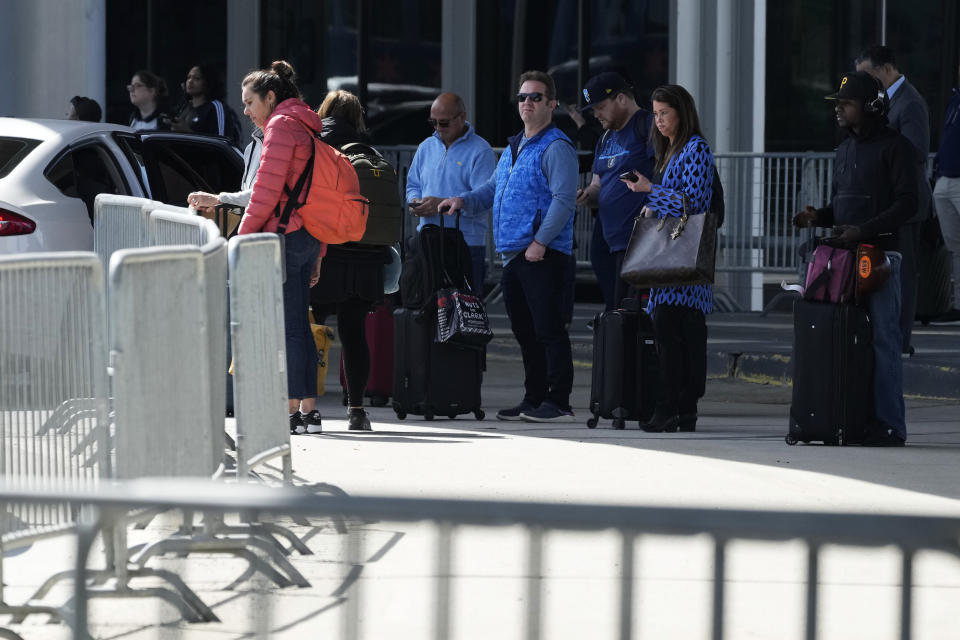 Travellers wait for an airport shuttle bus at O'Hare International Airport in Chicago, Monday, April 15, 2024. Pro-Palestinian demonstrators blocked a freeway leading to three Chicago O'Hare International Airport terminals Monday morning, temporarily stopping vehicle traffic into one of the nation's busiest airports and causing headaches for travelers. (AP Photo/Nam Y. Huh)