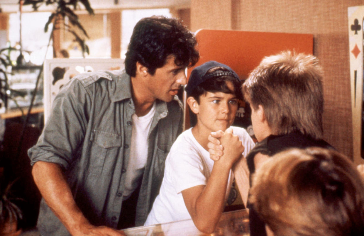 Stallone and David Mendenhall have some father/son bonding and arm wrestling time in Over the Top. (Warner Bros./Courtesy Everett Collection)