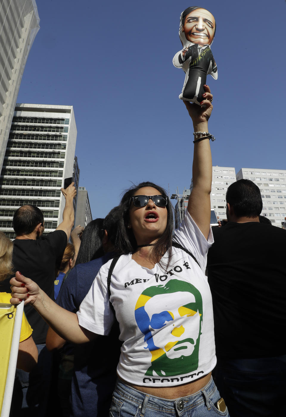 A supporter of Jair Bolsonaro, presidential candidate for the National Social Liberal Party who was stabbed during a campaign event days ago, holds up a doll in his image during a march along Paulista Avenue to show support for him in Sao Paulo, Brazil, Sunday, Sept. 9, 2018. Brazil will hold general elections on Oct. 7. (AP Photo/Andre Penner)