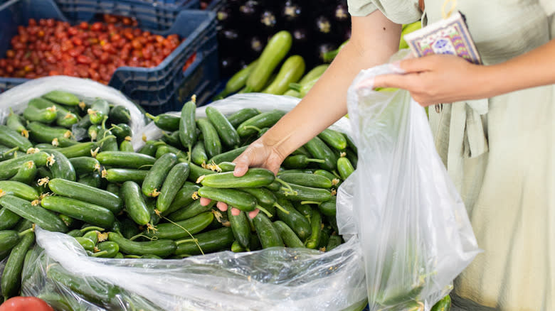 Woman selecting cucumbers at street market