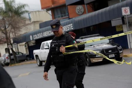 A police officer cordons off access to the Colegio Americano del Noreste after a student opened fire at the American school in Monterrey, Mexico January 18, 2017. REUTERS/Daniel Becerril