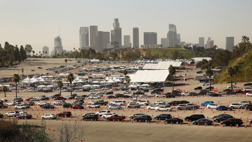 LOS ANGELES, CA - FEBRUARY 25: Vehicles wind their way through the parking lots at Los Angeles Dodger Stadium for COVID-19 vaccinations which is one of the largest vaccination sites in the country. It is one of five city-run vaccination sites working in partnership with actor Sean Penn's nonprofit Core (Community Organized Relief Effort). Vehicles arriving off of Academy Road are directed to one of three different areas where the vaccine is being administered to people in their vehicles. Dodger Stadium on Thursday, Feb. 25, 2021 in Los Angeles, CA. (Al Seib / Los Angeles Times).