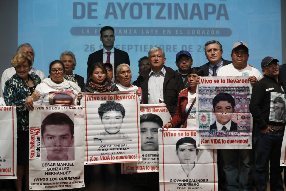 President-elect Andres Manuel Lopez Obrador, center, poses with the relatives of some the 43 college students who disappeared on Sept. 26, 2014, at the Memory and Tolerance Museum in Mexico City, Wednesday, Sept. 26, 2018. Later in the day, family members and supporters, who do not accept the findings of government investigations, will march to mark four years since the students disappearance at the hands of police. (AP Photo/Rebecca Blackwell)