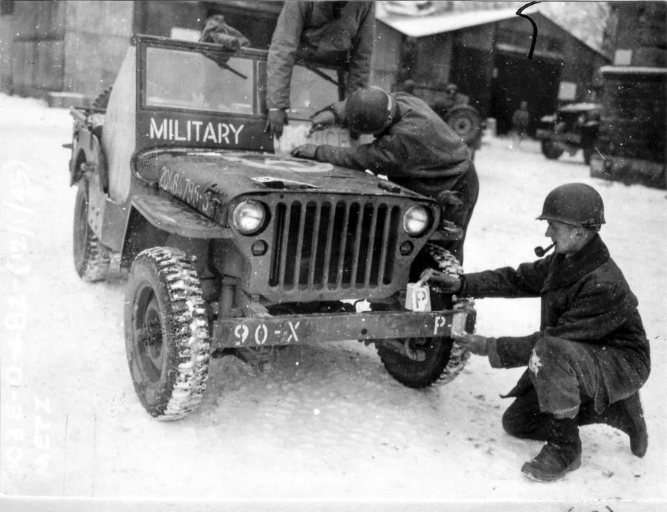 This photo provided by the Ghost Army Legacy Project shows a Jeep getting new bumper markings for special effects For decades, their mission during World War II was a secret. With inflatable tanks, trucks and planes, combined with sound effects, radio trickery, costume uniforms and acting, the American military units that became known as the Ghost Army helped outwit the enemy. Now, they are being awarded the Congressional Gold Medal on Thursday, March 21, 2024. (National Archives/Ghost Army Legacy Project via AP)