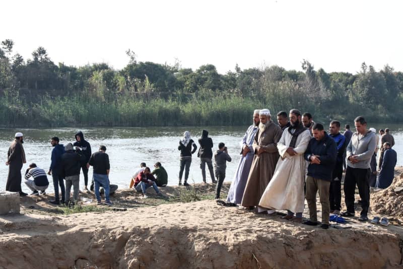 Villagers perform funeral prayers along the shore of the river Nile in Monsha'et El Kanater, after a ferry boat carrying labourers sunk leaving at least three people dead. Search and rescue efforts are under way for missing people in the accident, Egyptian media reported. The small boat was carrying eight to 10 workers when it sank, state-owned newspaper al-Ahram reported online. Mahmoud Elkhwas/dpa