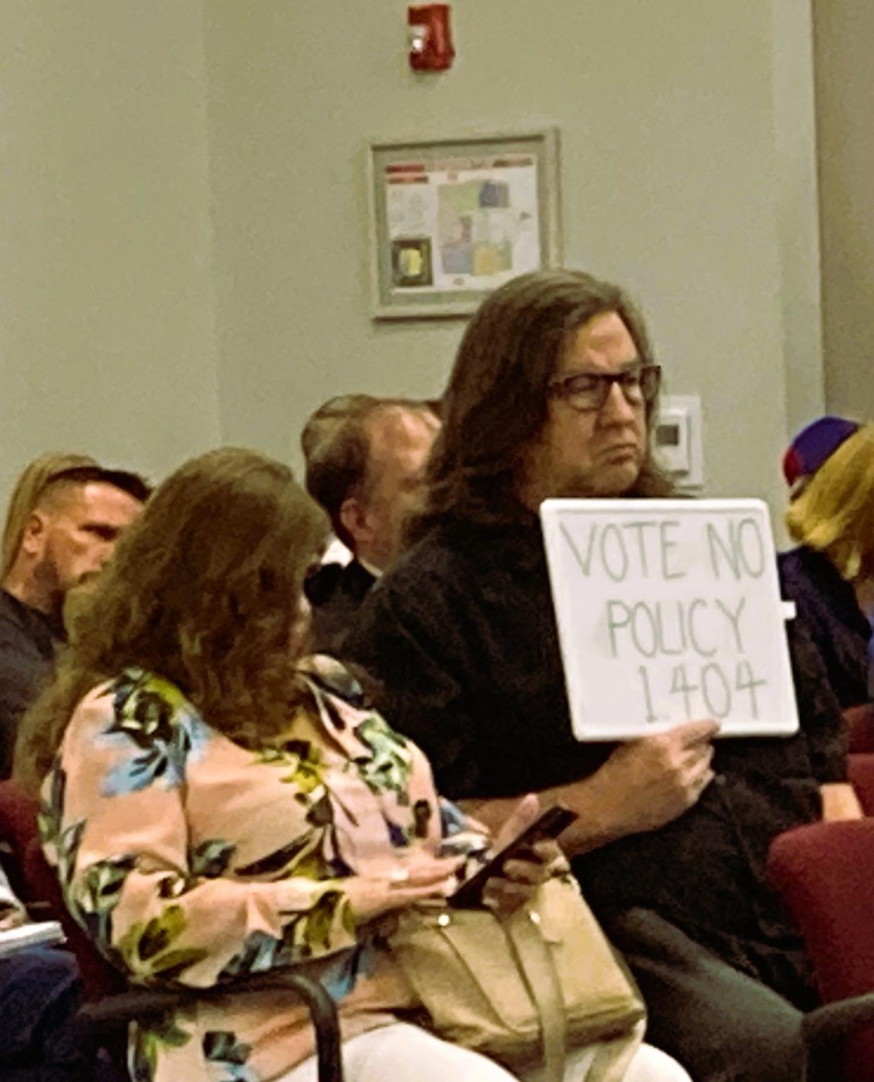 Kevin R. Woods holds a sign Thursday, April 18, 2024, asking Rutherford County Board of Education to vote no on Policy 1.404 that would limit public comment speeches to only agenda items.