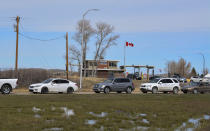 In this Wednesday, April 28, 2021, photo, cars line up at the Piegan-Carway border crossing between Montana and Canada, near Babb, Mont. The Blackfeet tribe gave out surplus vaccines to its First Nations relatives and others from across the border. (AP Photo/Iris Samuels)