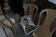 A Palestinian man gives away posters with a picture of Palestinian prisoner that says "freedom for the sick prisoner Nasser Abu Ehmad, sentenced for seven life imprisonments and fifty years," during a protest in the West Bank city of Ramallah, Tuesday, Sept. 14, 2021. Hundreds of thousands of Palestinians have passed through a military justice system designed for a temporary occupation that is now well into its sixth decade. Nearly every Palestinian has a loved one who has been locked up in that system at some point, and imprisonment is widely seen as one of the most painful aspects of life under Israeli rule. (AP Photo/Nasser Nasser)