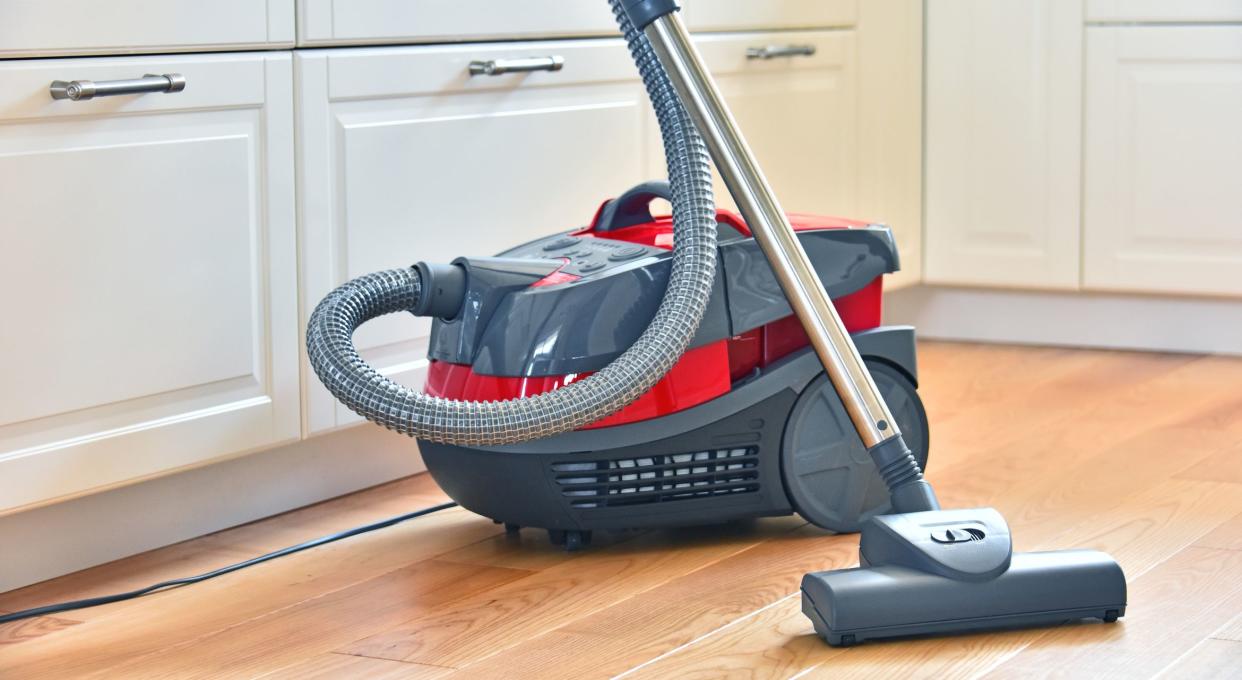 Canister vacuum cleaner for home use on the floor in the apartment.