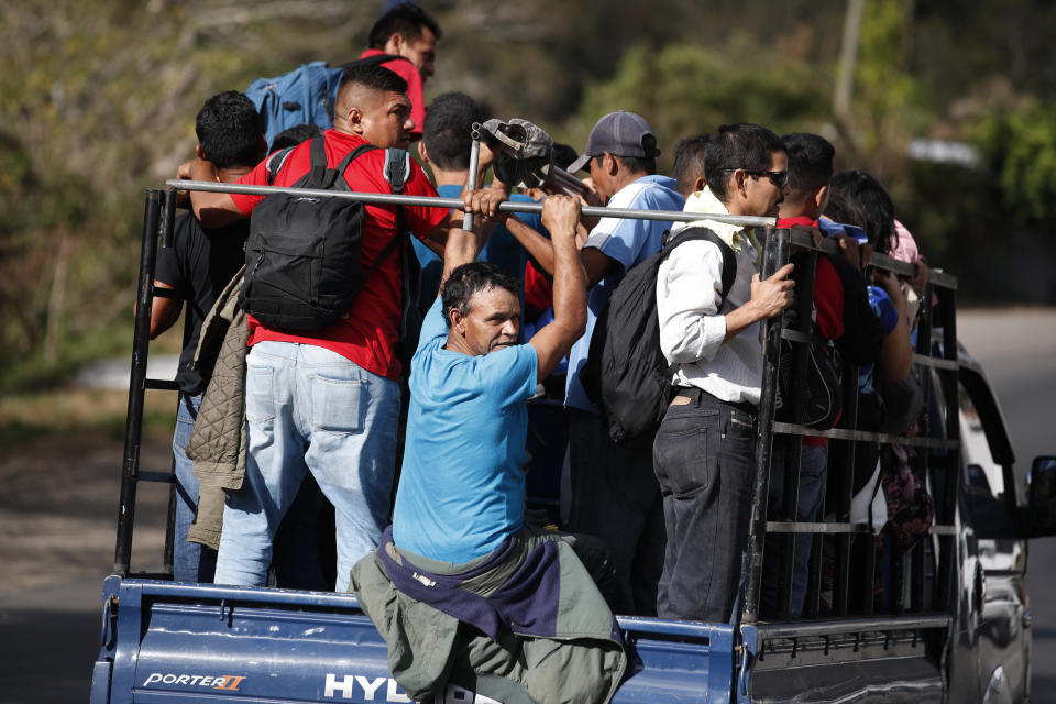 Honduran migrants get a ride on the back of a truck as they travel north in hopes of reaching the distant United States, in Quezaltepeque, Guatemala, Friday, Jan. 17, 2020. The group departed San Pedro Sula on Jan. 15. (AP Photo/Moises Castillo)