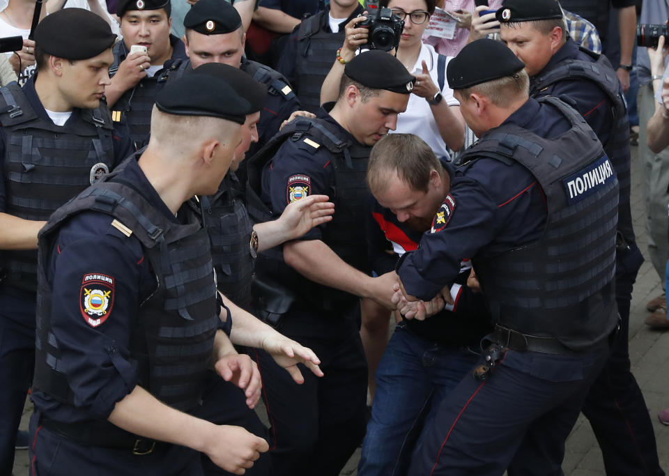 Police officers detain a protester during a march in Moscow, Russia, Wednesday, June 12, 2019. Police and hundreds of demonstrators are facing off in central Moscow at an unauthorized march against police abuse in the wake of the high-profile detention of a Russian journalist. More than 20 demonstrators have been detained, according to monitoring group. (AP Photo/Pavel Golovkin)