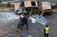 Lebanese police detain a suspect at the site of an explosion in downtown Beirut December 27, 2013. Former Lebanese minister Mohamad Chatah, who opposed Syrian President Bashar al-Assad, was killed in a massive bomb blast which one of his political allies blamed on Lebanon's Shi'ite Hezbollah militia. (REUTERS/Mohamed Azakir)