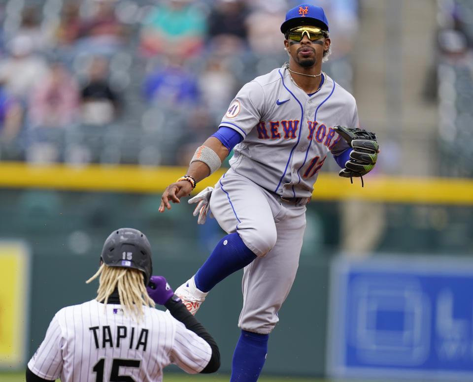 New York Mets shortstop Francisco Lindor, right, forces out Colorado Rockies' Raimel Tapia at second base on the front end of a double-play ball hit by Ryan McMahon in the first inning of a baseball game Sunday, April 18, 2021, in Denver. (AP Photo/David Zalubowski)