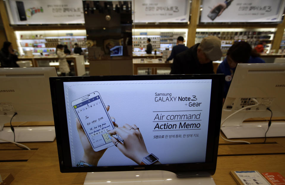 In this photo taken on Jan. 7, 2014, a screen displays text advertising Samsung Electronics' Galaxy Note 3 smartphones and Galaxy Gear smartwatches at a Samsung Electronics shop in Seoul, South Korea. For the first time in more than two years, Samsung's quarterly net profit declined from the previous quarter, the South Korean electronics powerhouse said Friday, Jan. 24, 2014, amid deepening concerns about slowing growth in smartphone markets. (AP Photo/Lee Jin-man)