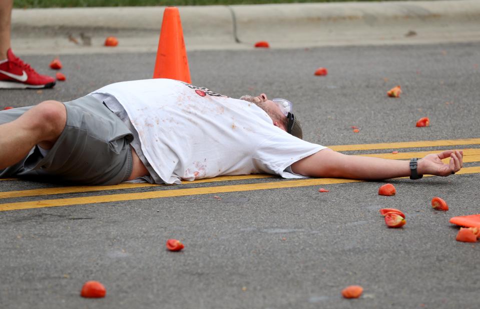A competitor in the Tomato Wars succumbs to a barrage of the pulpy fruit at the Reynoldsburg Tomato Festival.