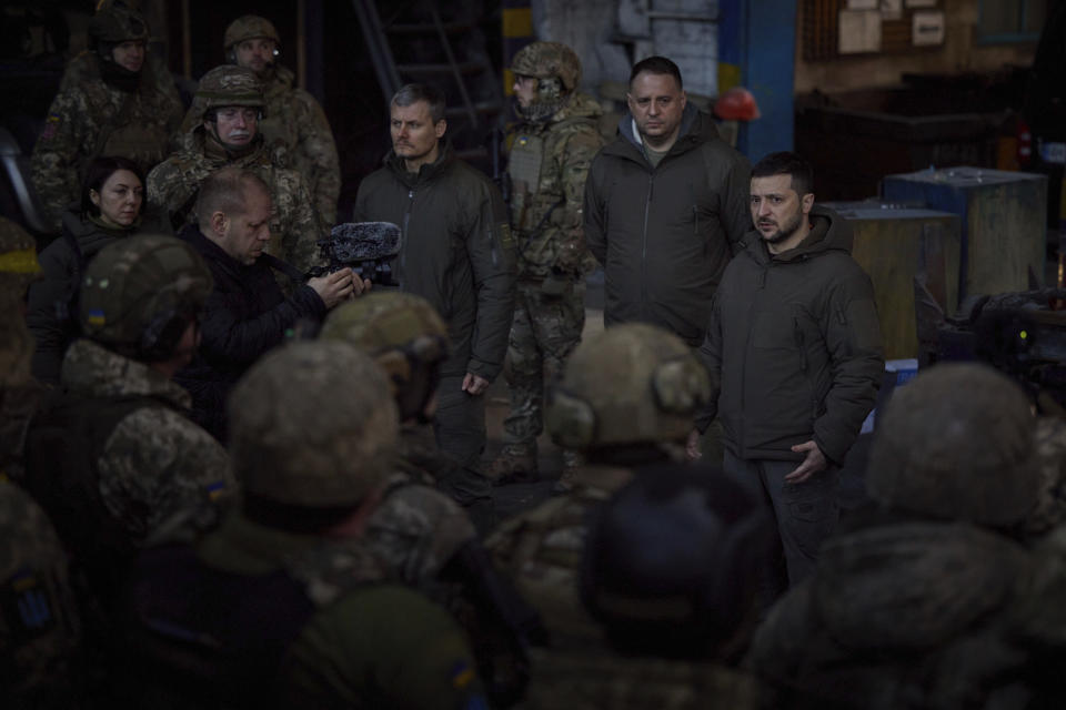 In this photo provided by the Ukrainian Presidential Press Office, Ukrainian President Volodymyr Zelenskyy, right, speaks to soldiers at the site of the heaviest battles with the Russian invaders, in Bakhmut, Ukraine, Tuesday, Dec. 20, 2022. (Ukrainian Presidential Press Office via AP)