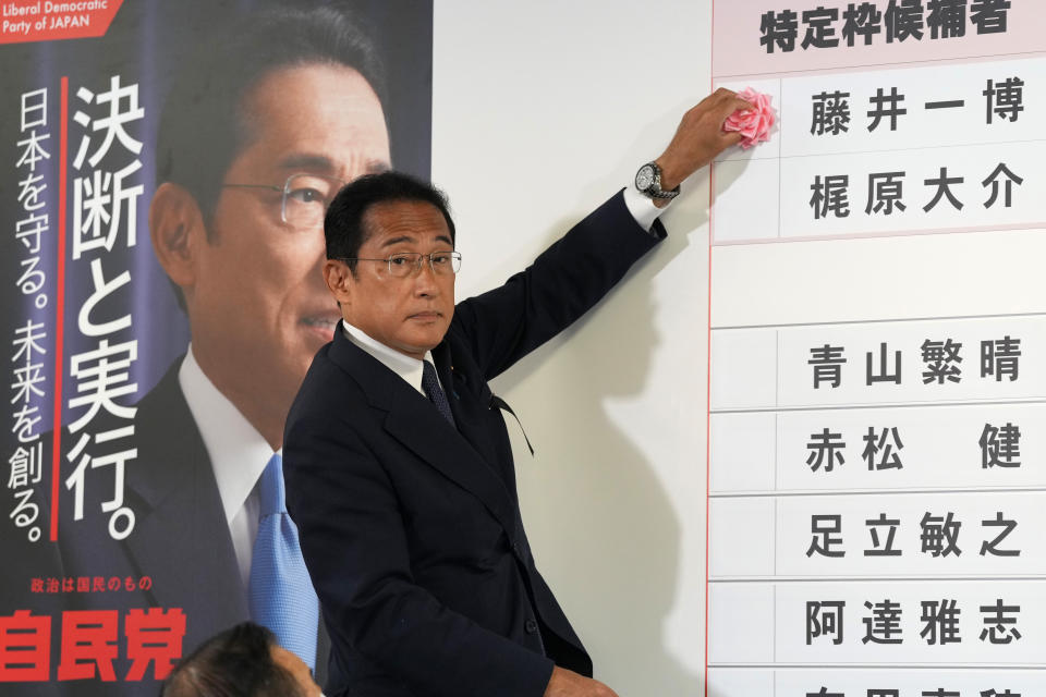 Ministerpräsident Fumio Kishida platziert eine Rose neben dem Namen eins LDP-Kandidaten, um den Sieg in den Parlamentswahlen anzuzeigen.