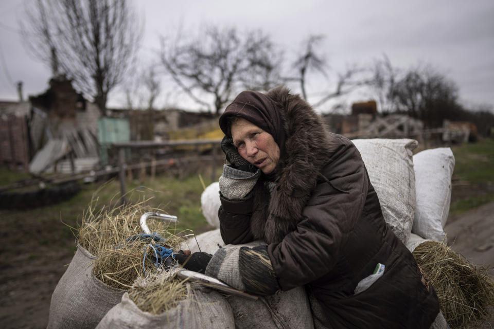 Kateryna, 62, looks on to her house destroyed by Russian forces' shelling in the outskirts of Chernihiv, Ukraine, Wednesday, April 13, 2022. (AP Photo/Evgeniy Maloletka)