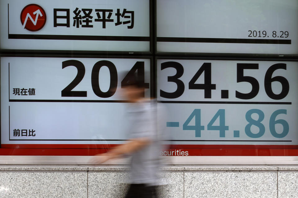 A man walks past an electronic stock board showing Japan's Nikkei 225 index at a securities firm in Tokyo Thursday, Aug. 29, 2019. Asian stocks declined Thursday following Wall Street's rebound amid uncertainty about U.S.-Chinese trade tension. (AP Photo/Eugene Hoshiko)