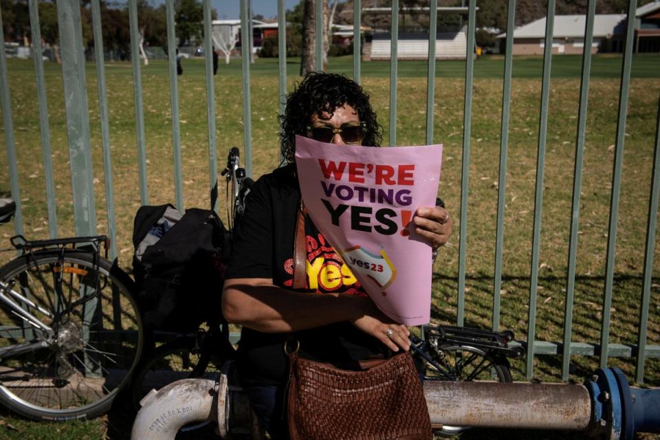A woman holds up a sign supporting the Voice to Parliament at the Walk for Yes event in Alice Springs (Reuters)
