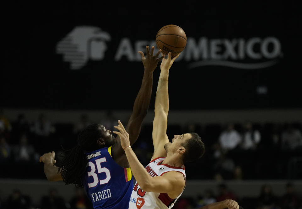 Kennet Faried, de los Capitanes de Ciudad de México, disputa el salto entre dos ante Marko Simonovic, de los Windy City Bulls, el domingo 12 de marzo de 2023 (AP Foto/Fernando Llano)