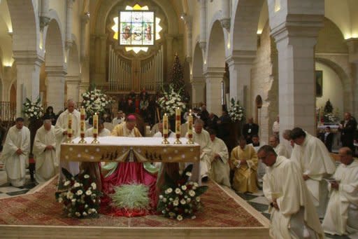 The Latin Patriarch of Jerusalem Fuad Twal (Back-C), the head of the Roman Catholic Church in the Holy Land, leads the Christmas morning mass at the Church of the Nativity in the West Bank town of Bethlehem on December 25, 2012