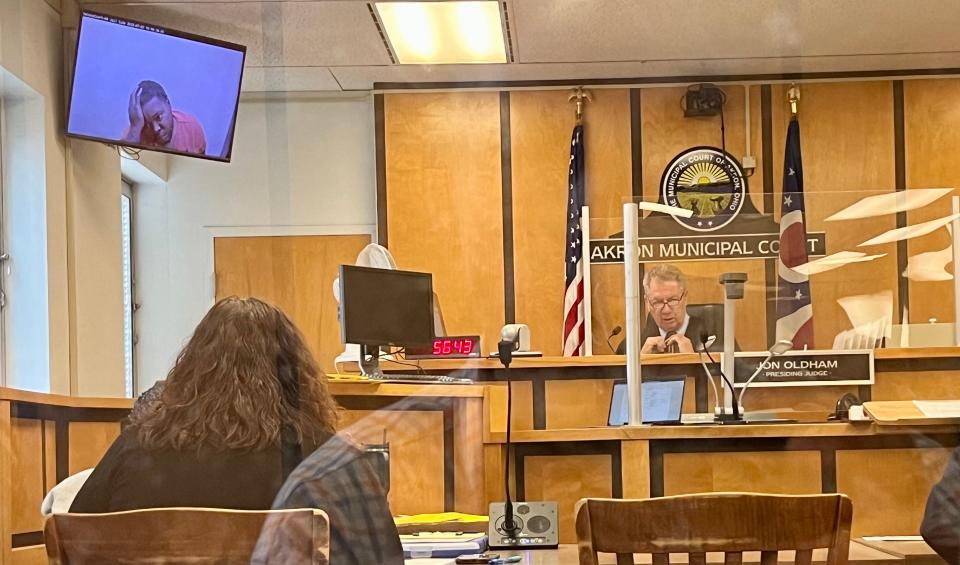 Jordan Ely Sr. holds his head in his hand as a visiting judge sets the bond for new charges of resisting arrest, obstruction of justice and felony drug possession Monday following a forceful arrest by Akron police Saturday.