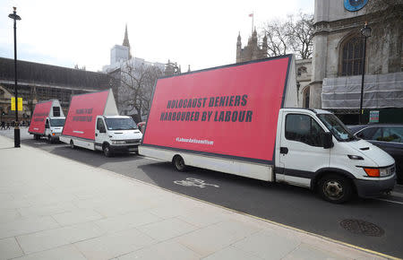 Vans with slogans aimed at Britain's Labour Party are driven around Parliament Square ahead of a debate on antisemitism in Parliament, in London, April 17, 2018. REUTERS/Hannah McKay