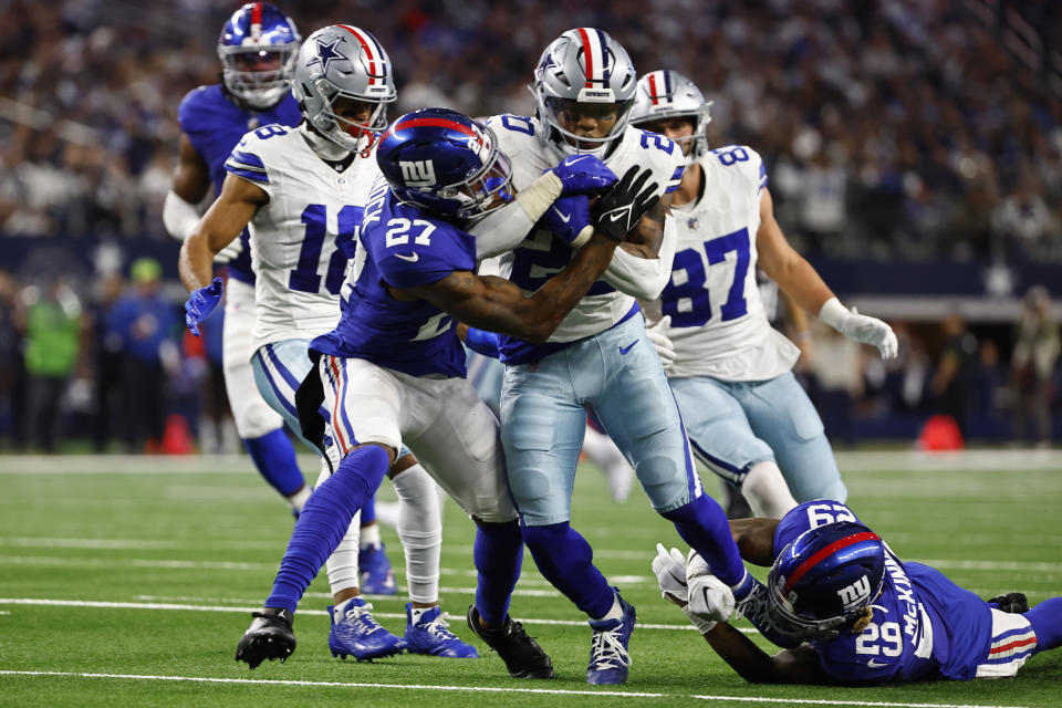 Dallas Cowboys running back Tony Pollard, center, is tackled by New York Giants safety Jason Pinnock (27) and safety Xavier McKinney (29) in the first half of an NFL football game, Sunday, Nov. 12, 2023, in Arlington, Texas. (AP Photo/Roger Steinman)