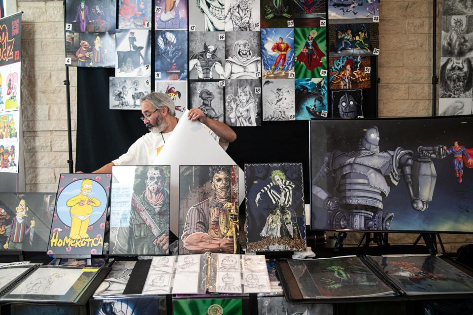 Artist Steve Garcia, of Austin, signs prints at Corpus Christi Comic Con in the American Bank Center on Friday, July 28, 2023.