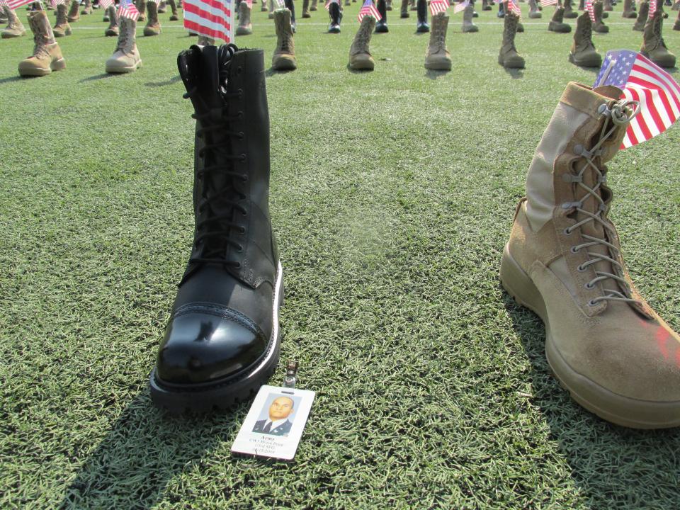 Volunteers place more than 7,500 boots out Friday, May 20, 2022, at Hedrick Stadium on Fort Bragg to represent service members who have died since 9/11.