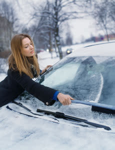 woman scraping ice off car