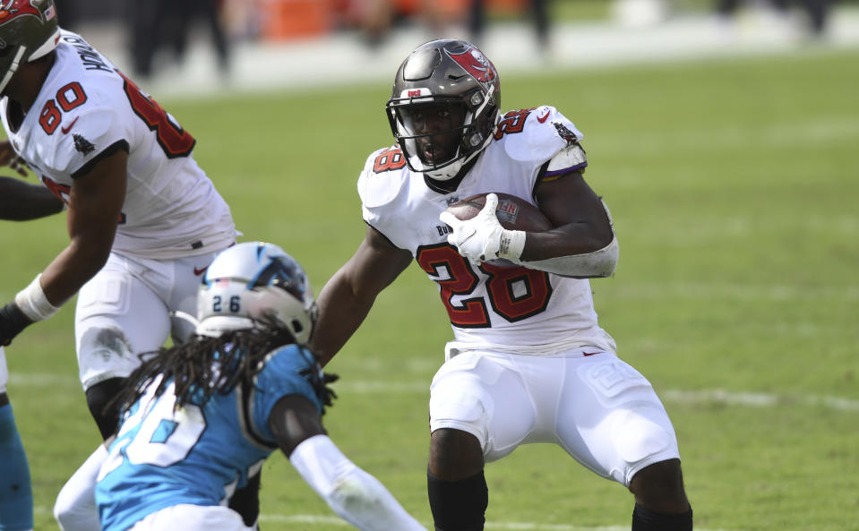 Tampa Bay Buccaneers running back Leonard Fournette (28) runs at Carolina Panthers cornerback Donte Jackson (26) during the second half of an NFL football game Sunday, Sept. 20, 2020, in Tampa, Fla. (AP Photo/Jason Behnken)