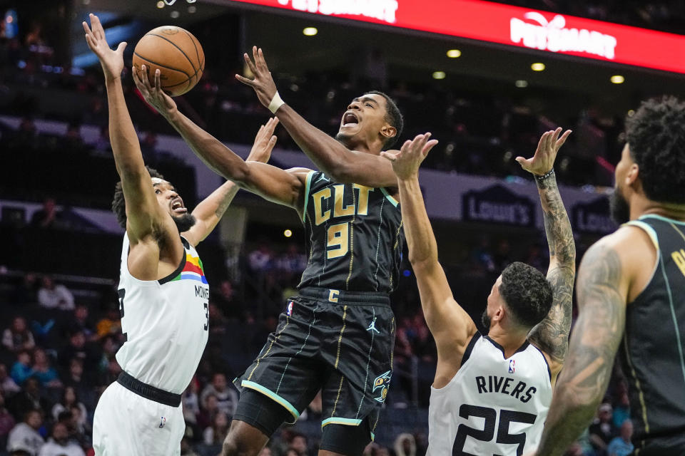 Charlotte Hornets guard Theo Maledon, center, drives between Minnesota Timberwolves center Karl-Anthony Towns, left and guard Austin Rivers during the first half of an NBA basketball game Friday, Nov. 25, 2022, in Charlotte, N.C. (AP Photo/Rusty Jones)