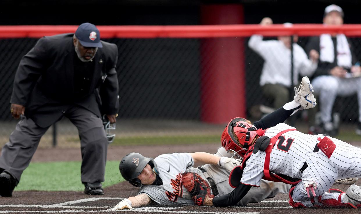 McKinley catcher Aaron Fawver tags out Massillon's Nick Selogy at the plate in the first inning of a game between the Bulldogs and Tigers earlier this month.