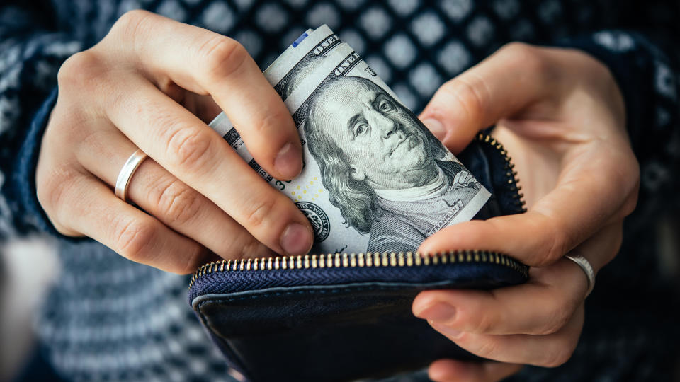 woman taking cash out of wallet