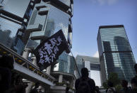 A demonstrator carries a flag reading "Liberate Hong Kong, Revolution of Our Times" outside the High Court in Hong Kong, Wednesday, Oct. 9, 2019. Several hundred masked protestors chanting for revolution have gathered at Hong Kong's High Court for the appeal hearing of an activist sentenced to six years in prison for his part in a violent nightlong clash with police. (AP Photo/Vincent Yu)