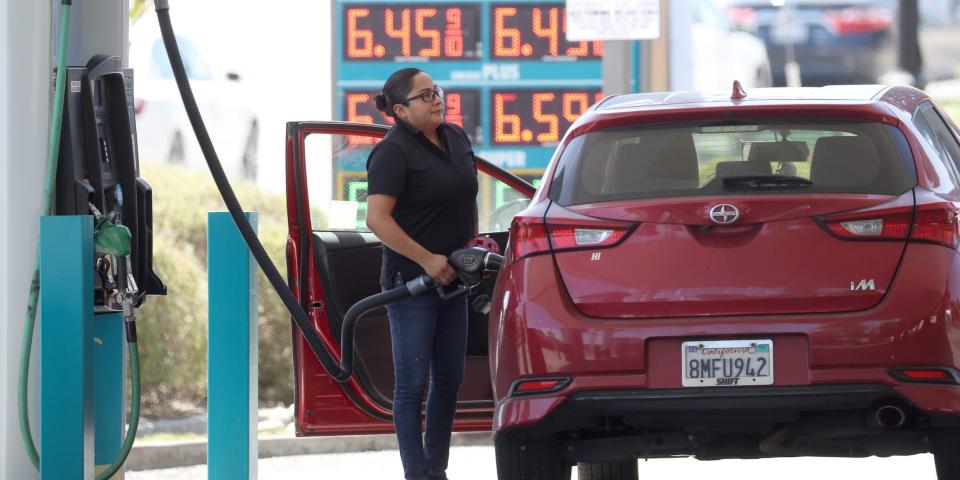 Woman pumps gas as prices hit record highs.