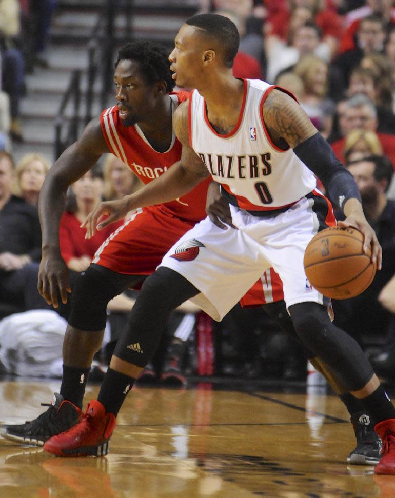 Houston Rockets' Patrick Beverley (2) defends against Portland Trail Blazers' Damian Lillard (0) during the first half of game four of an NBA basketball first-round playoff series game in Portland, Ore., Sunday March 30, 2014. (AP Photo/Greg Wahl-Stephens)