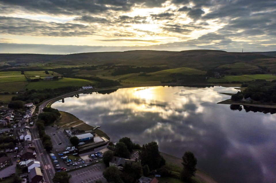 <p>The sun rises over Hollingworth Lake in Rochdale, Greater Manchester. Picture date: Sunday August 1, 2021.</p>
