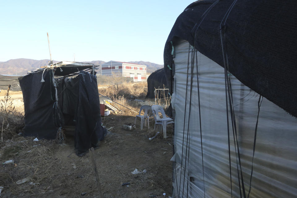 An outdoor toilet, left, is placed beside a dormitory for migrant workers at a farm in Pocheon, South Korea on Feb. 8, 2021. Workers often are crammed in shipping containers or flimsy, poorly ventilated huts. (AP Photo/Ahn Young-joon)
