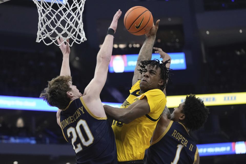 Marquette's Zaide Lowery shoots past Notre Dame's J.R. Konieczny and Julian Roper II during the first half of an NCAA college basketball game Saturday, Dec. 9, 2023, in Milwaukee. (AP Photo/Morry Gash)